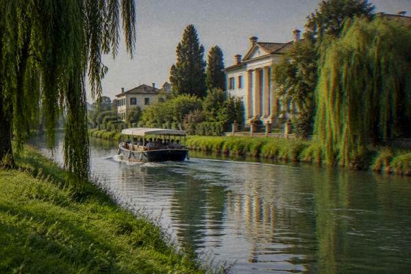 A small passenger boat gliding on a slow green canal between grassy banks and weeping willows, a pale villa glimpsed behind, Brenta Riviera