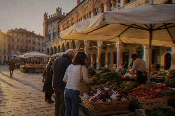 A small group choosing vegetables at a market stall under a plain umbrella with a cook, baskets of radicchio and tomatoes, Piazza delle Erbe