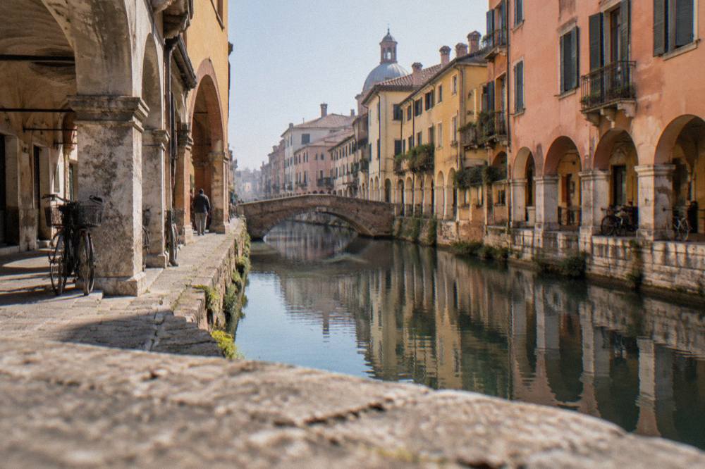 A canal lined with old stone buildings running through the centre of Padua