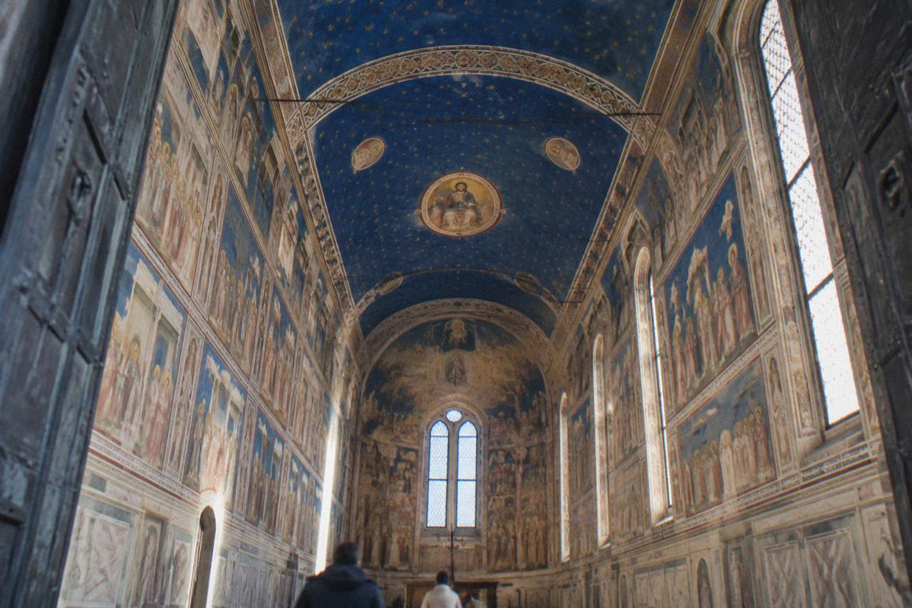 The blue and gold frescoed interior of the Scrovegni Chapel in Padua seen from the entrance