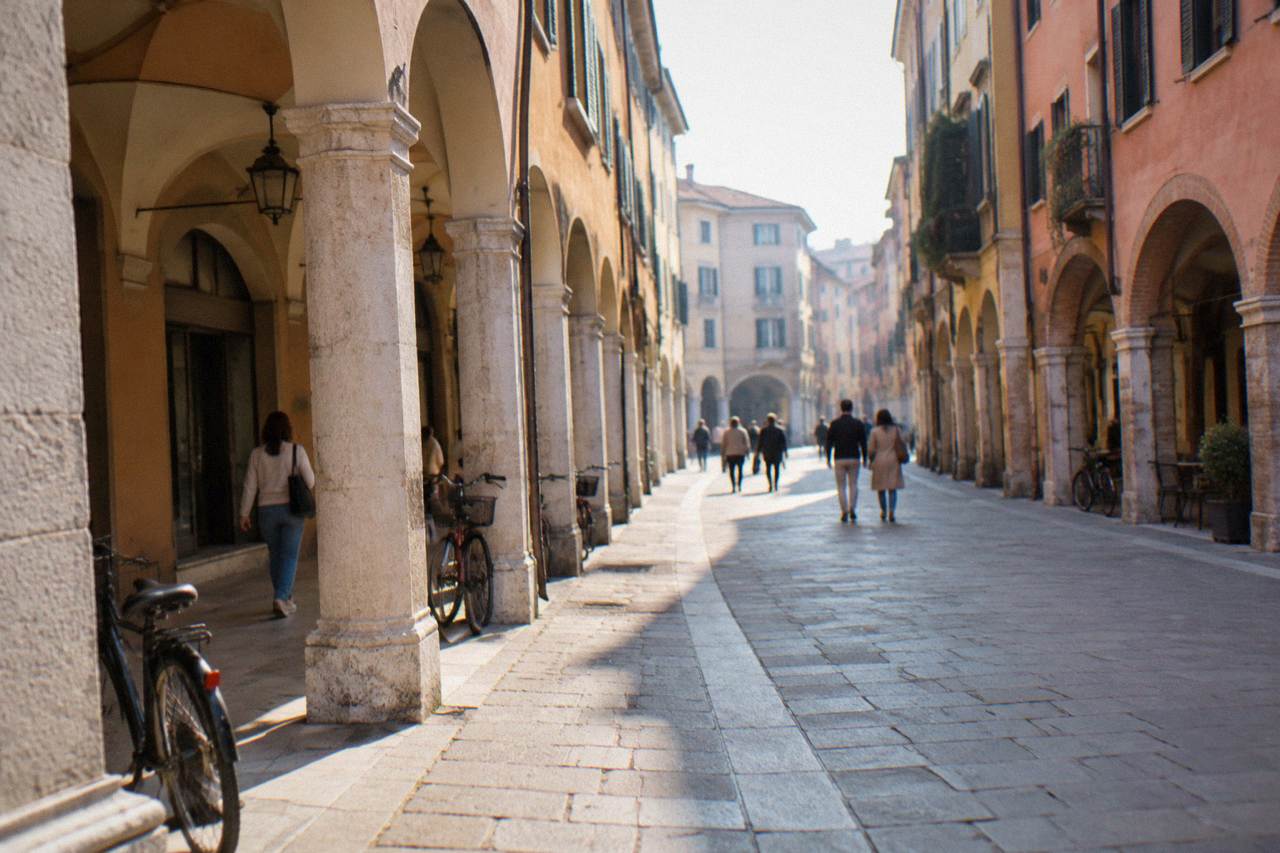 Arcaded street in central Padua with people strolling under the porticoes