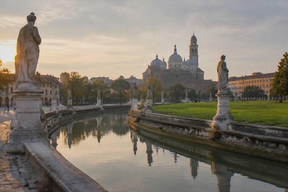 The canal and ring of statues around Prato della Valle in Padua at golden hour