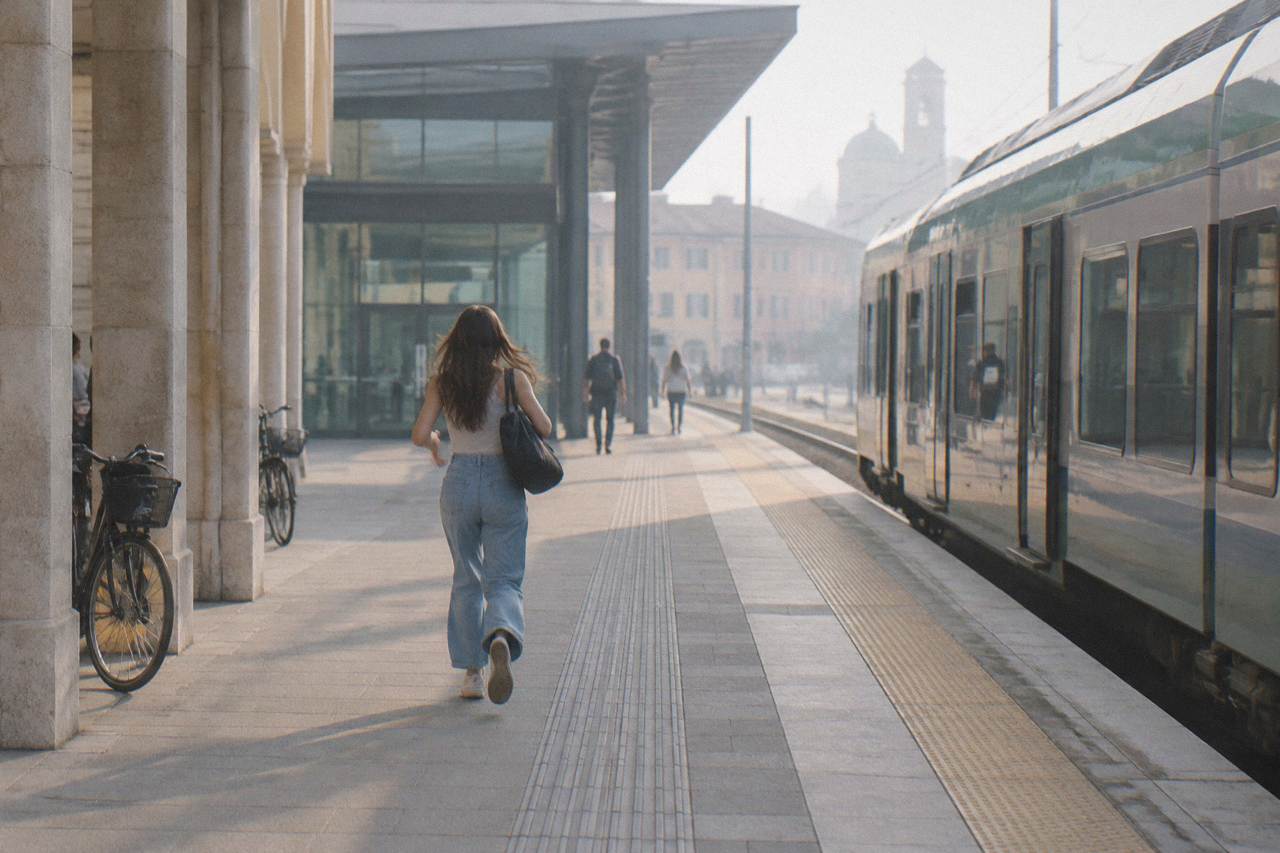 A regional train waiting at a platform beside the modern entrance of Padua railway station