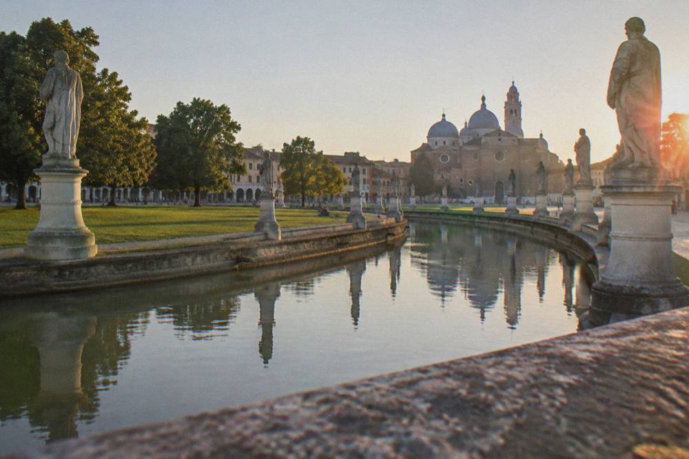 Prato della Valle in Padua with its canal and ring of statues on a clear day