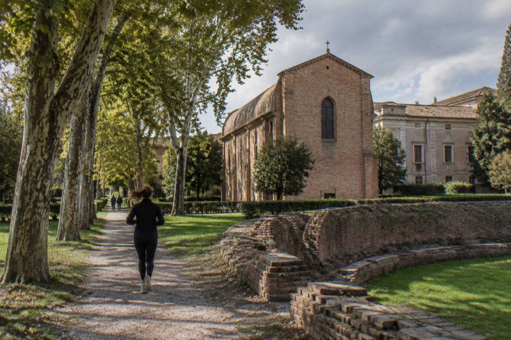 The exterior of the Scrovegni Chapel in Padua seen across a garden, a simple brick building beside the Eremitani museum complex