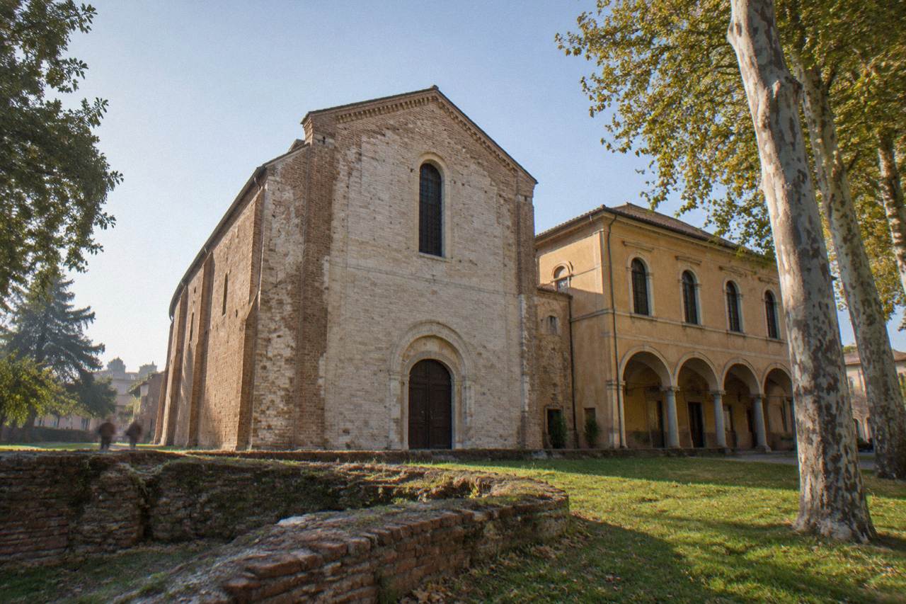 The facade of the Scrovegni Chapel in Padua under a clear sky, with the neighbouring museum building beside it