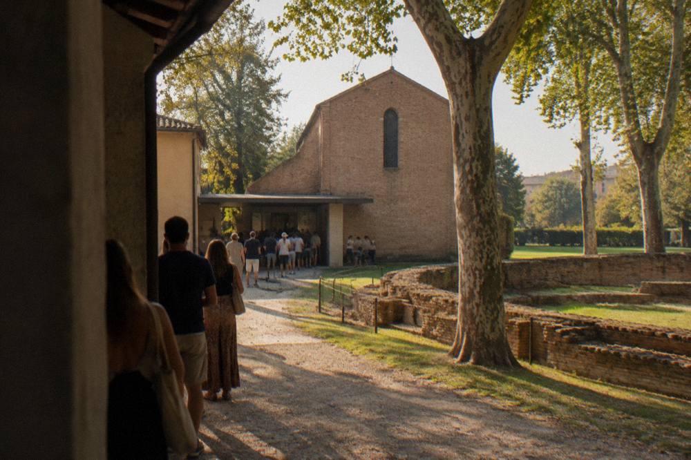 Visitors waiting outside the low entrance building of the Scrovegni Chapel in Padua on a warm afternoon
