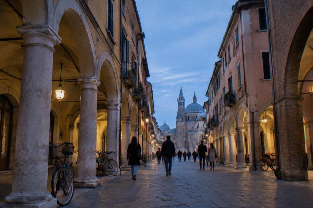 People walking under medieval arcades in the historic centre of Padua