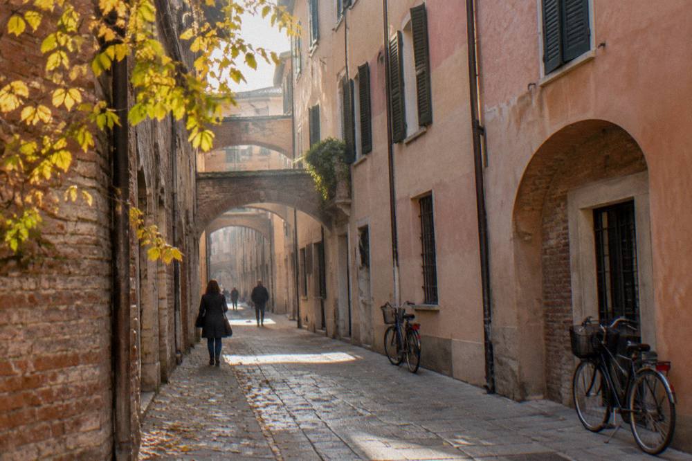 Sunlight falling on old brick facades above a narrow city street