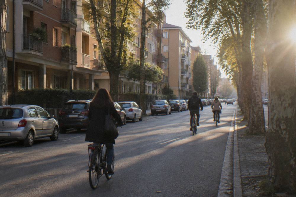 A residential street in the Arcella district of Padua with apartment buildings and cyclists