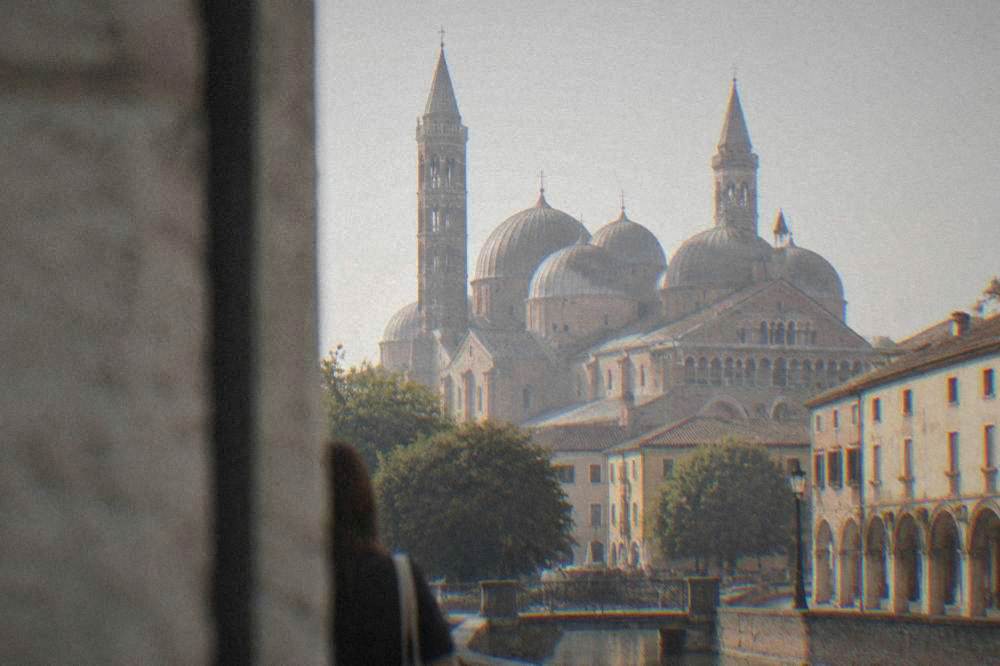 Pale domed basilica with slender towers seen from a quiet square
