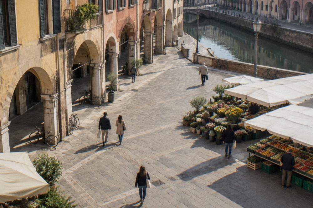 Market stalls with flowers and produce along the edge of a wide Padua square