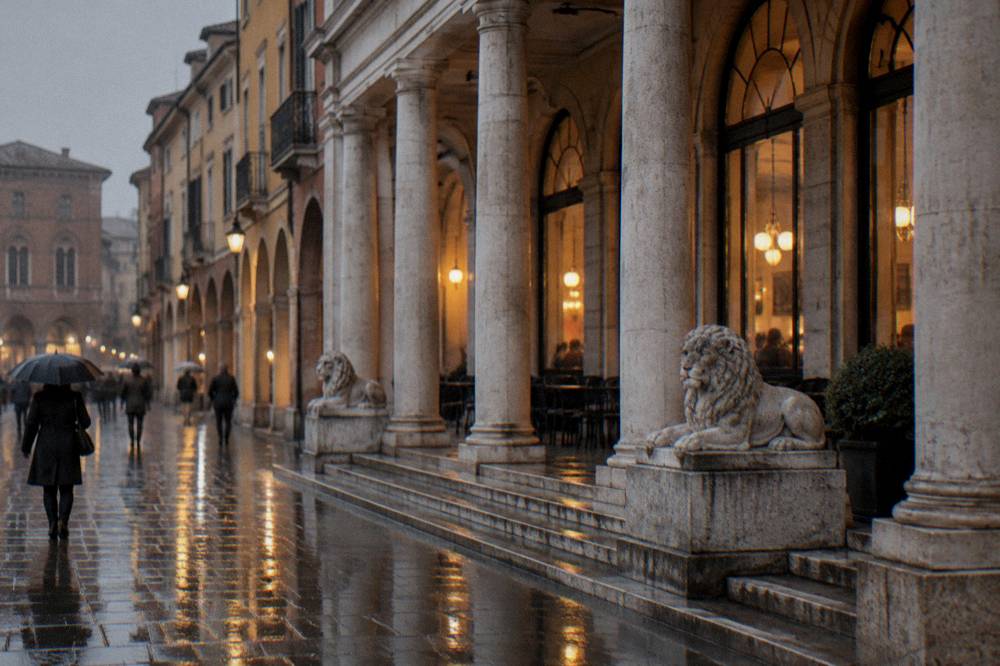 A historic cafe exterior at dusk with warm light through tall windows