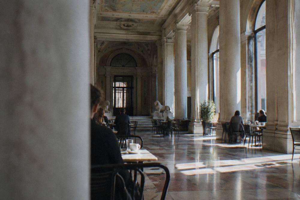 A tall neoclassical hall with columns and painted ceiling decoration