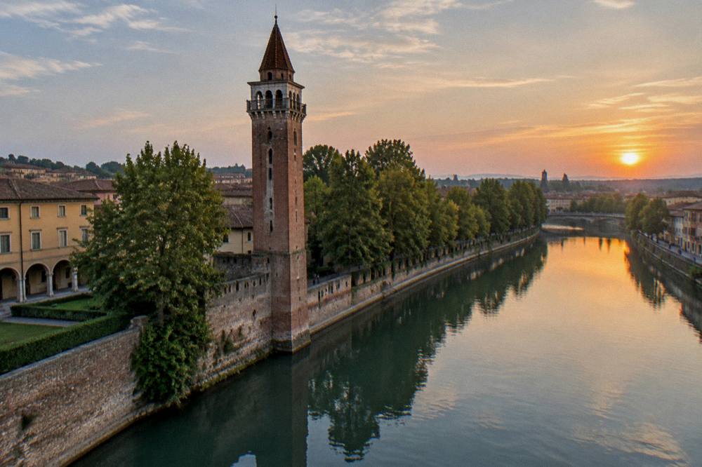 A river tower silhouetted at dusk with calm water reflecting the sky
