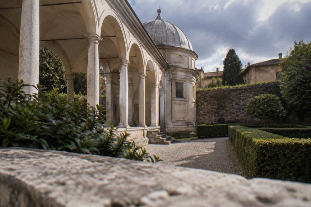 A quiet enclosed garden courtyard with clipped hedges and old walls