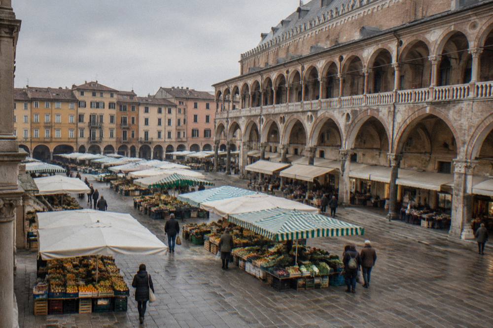 A market square in Padua with striped stalls and old arcaded buildings