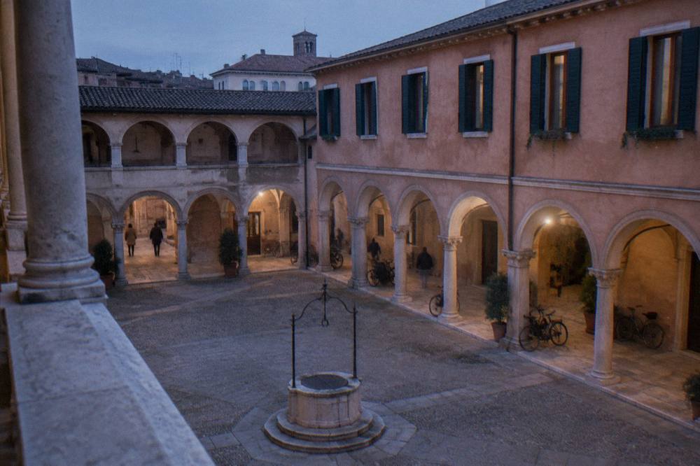 A Renaissance courtyard with arched loggias and a stone wellhead in Padua