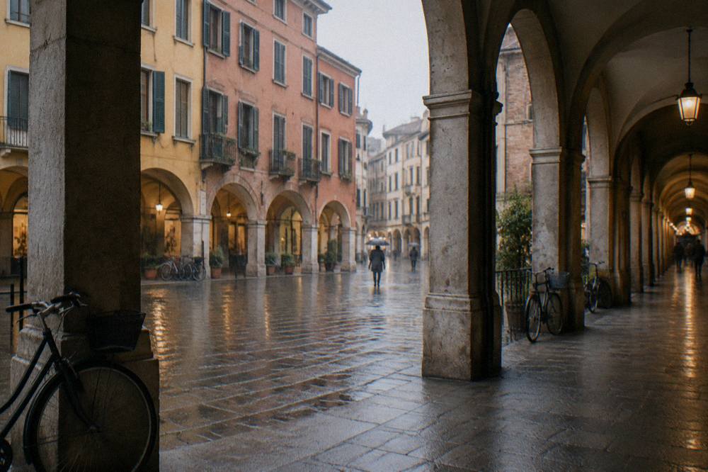A historic arcade street in Padua lit in the early evening