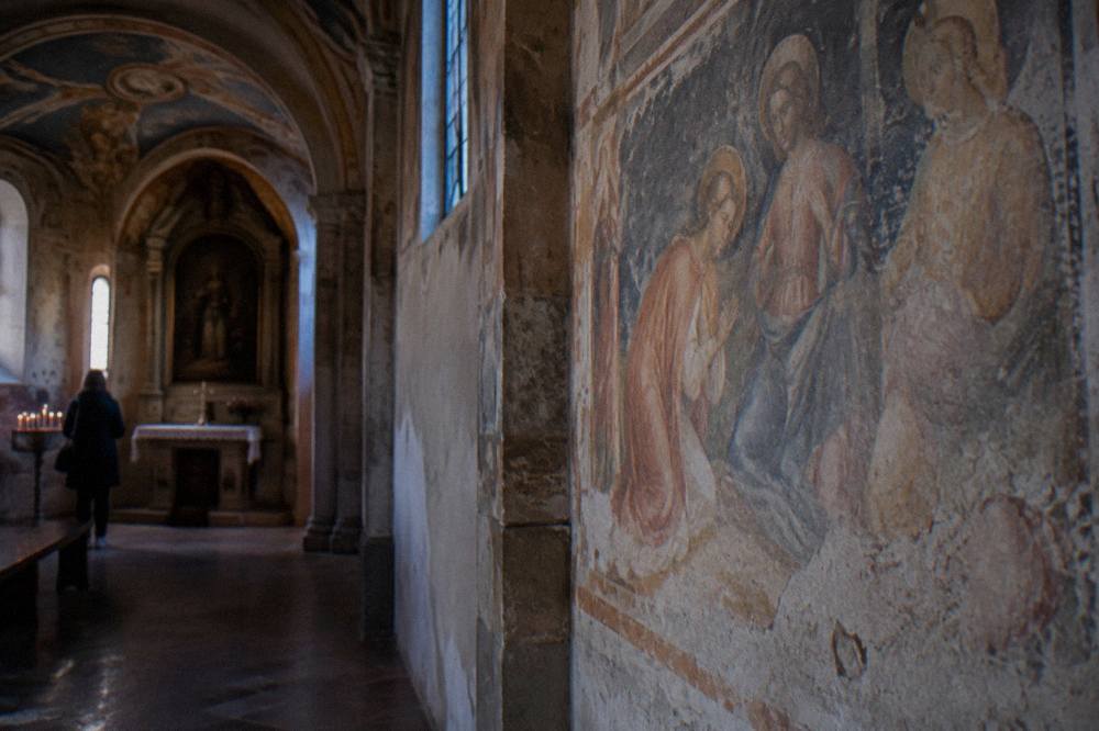 Interior wall frescoes with figures in a small chapel in Padua