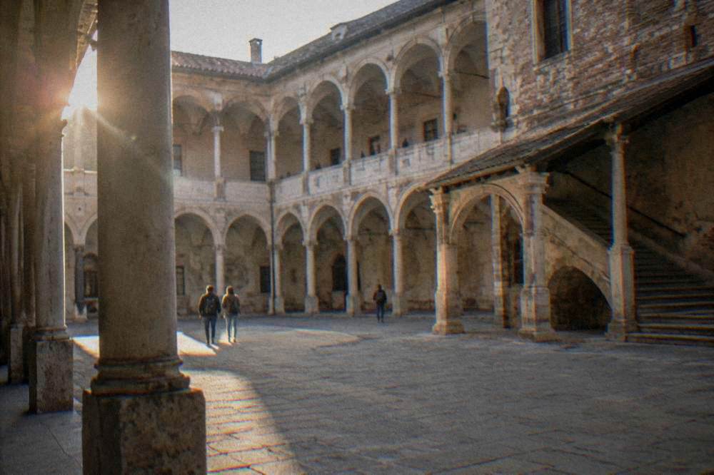 Courtyard of a historic university building with stone arcades
