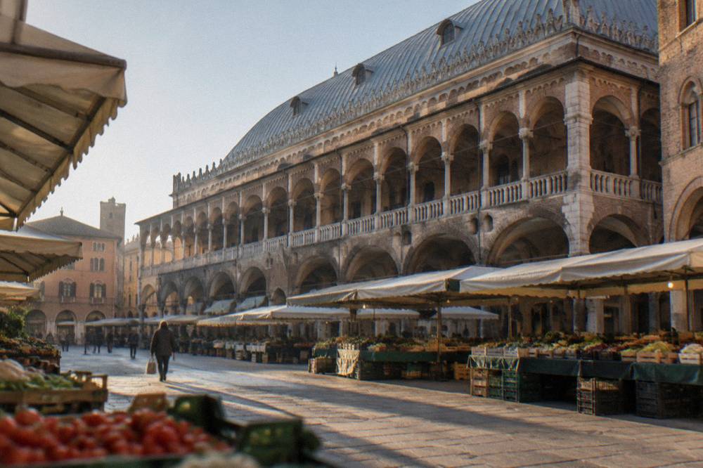 Exterior arcade of the Palazzo della Ragione seen from the Piazza dei Frutti with market awnings