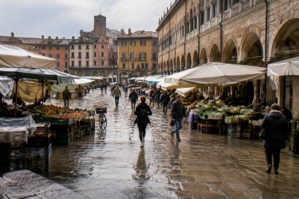 Aerial view of arcaded squares around a large roofed hall in an Italian city