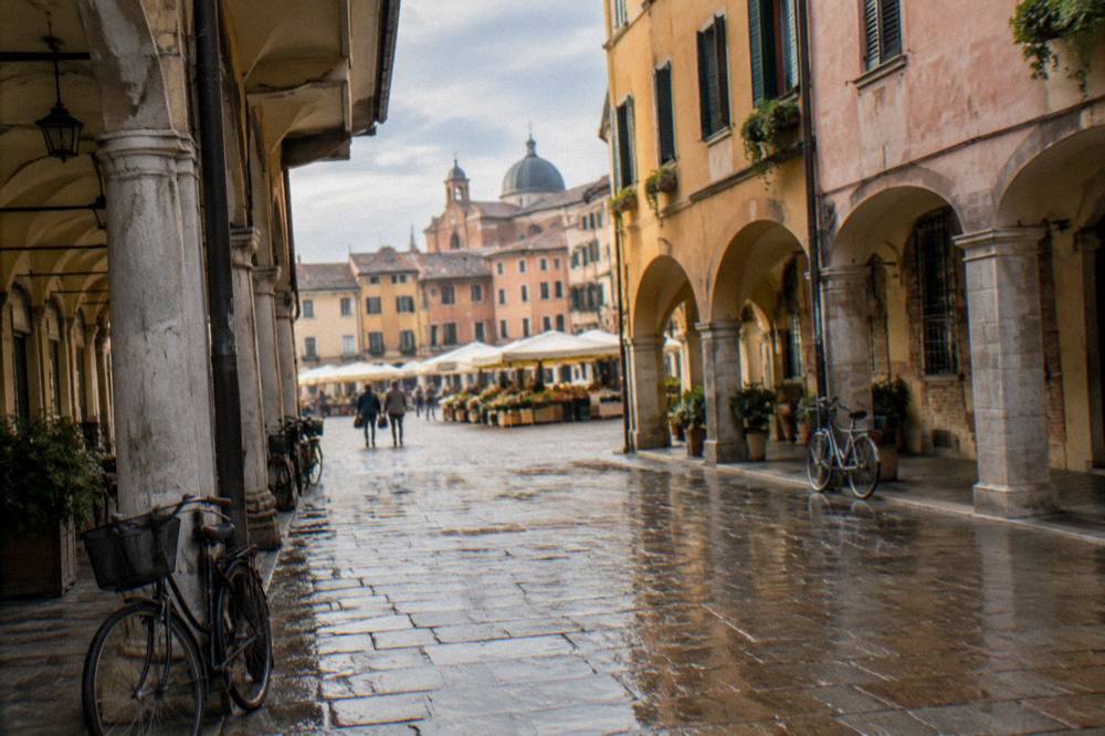 An arcaded street in Padua leading toward an open square with market awnings
