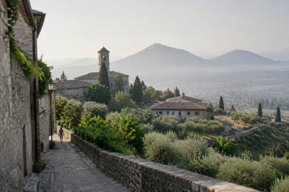 Rounded green hills of the Euganean range rising above misty plain at dawn