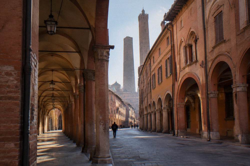 Porticoed medieval street in Bologna with warm brick facades and arcades