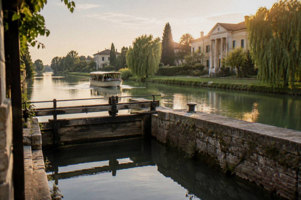 A canal lock gate with calm water on one side and a stone wall on the other