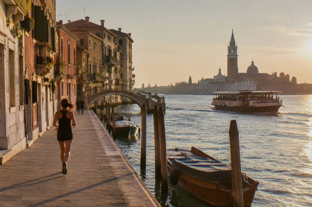A Venice public transport boat crossing open lagoon water toward island moorings