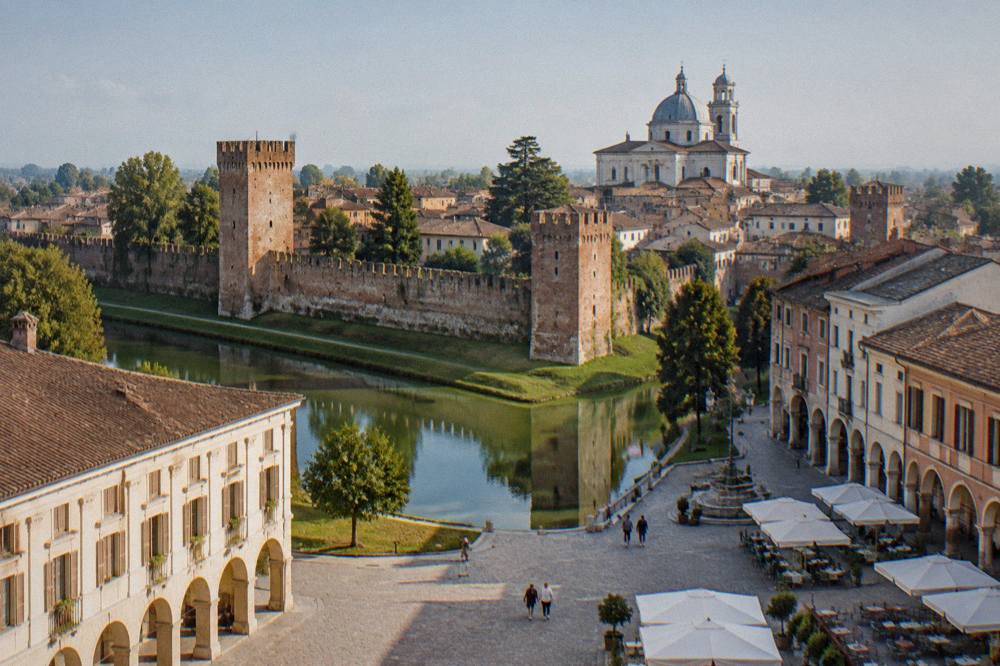 Arcaded square with cafe tables and historic buildings in a small Veneto town