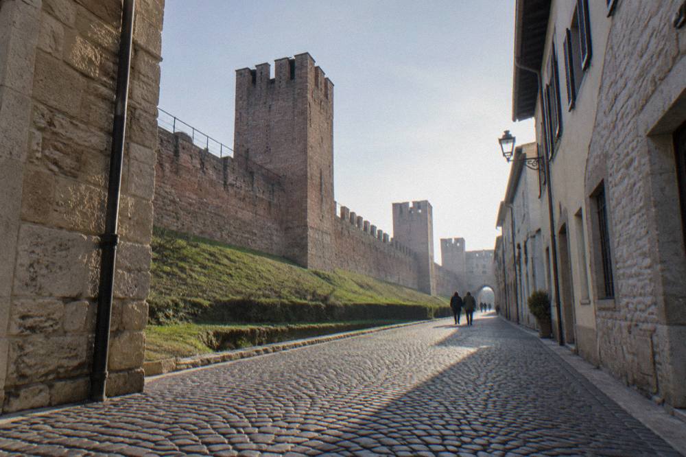 Cobbled street inside a walled town with stone buildings on both sides