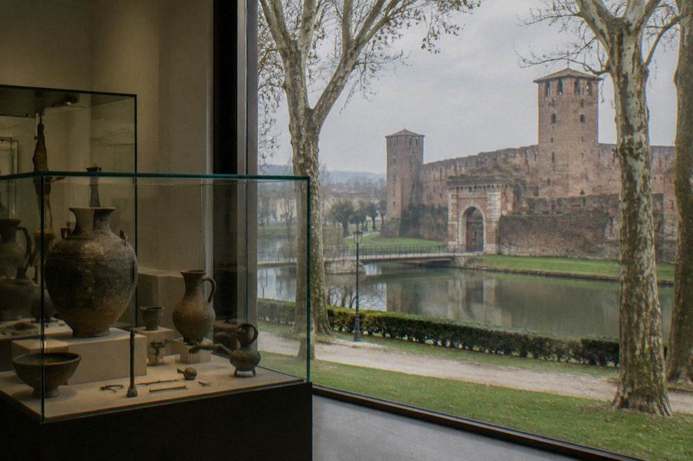Glass display cases with ancient pottery and bronze objects in a museum gallery