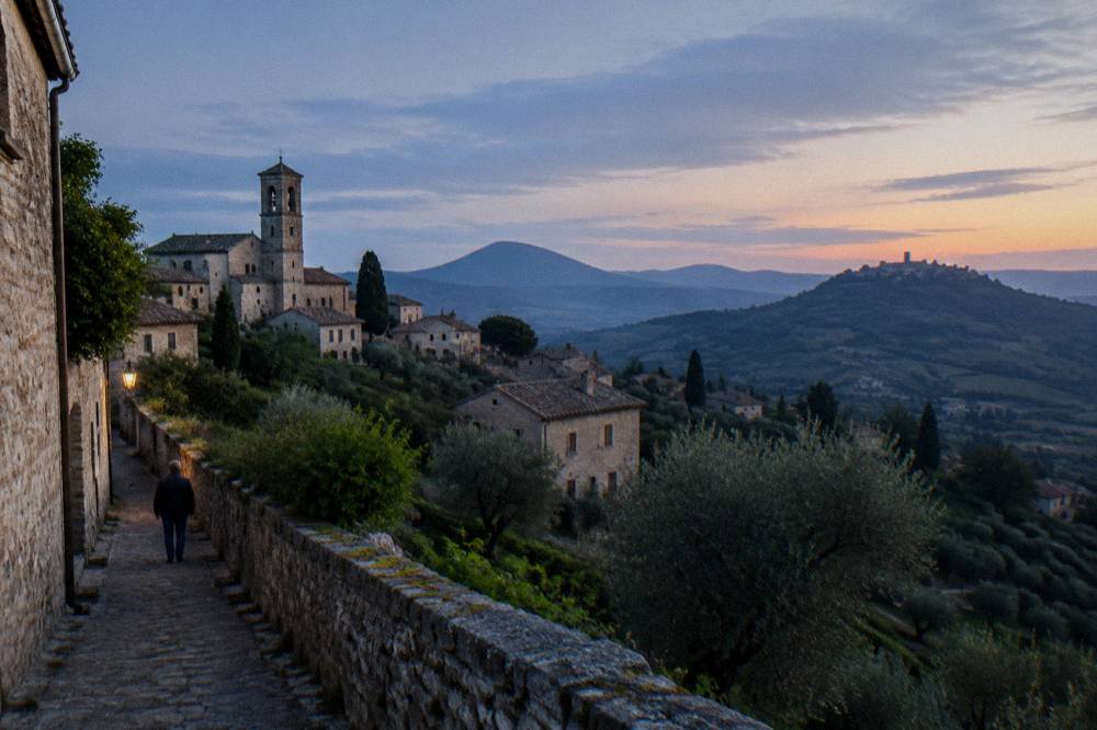 A panorama of volcanic hills with vineyards and a hilltop town silhouette