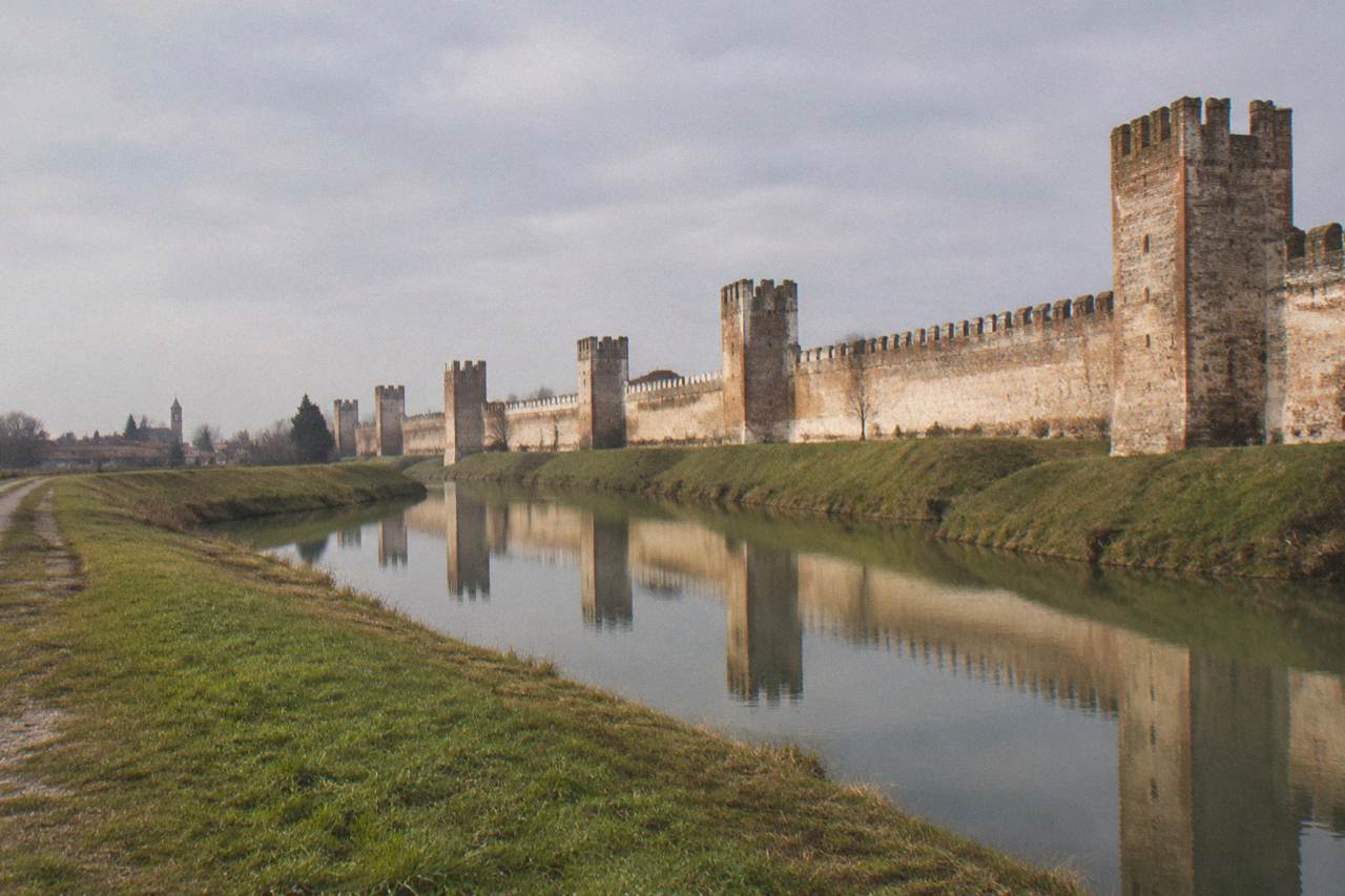 Medieval brick walls and towers of Montagnana seen across open countryside