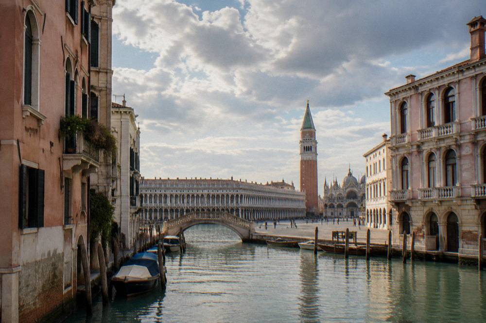 Piazza San Marco seen across the square with the campanile and arcaded Procuratie buildings