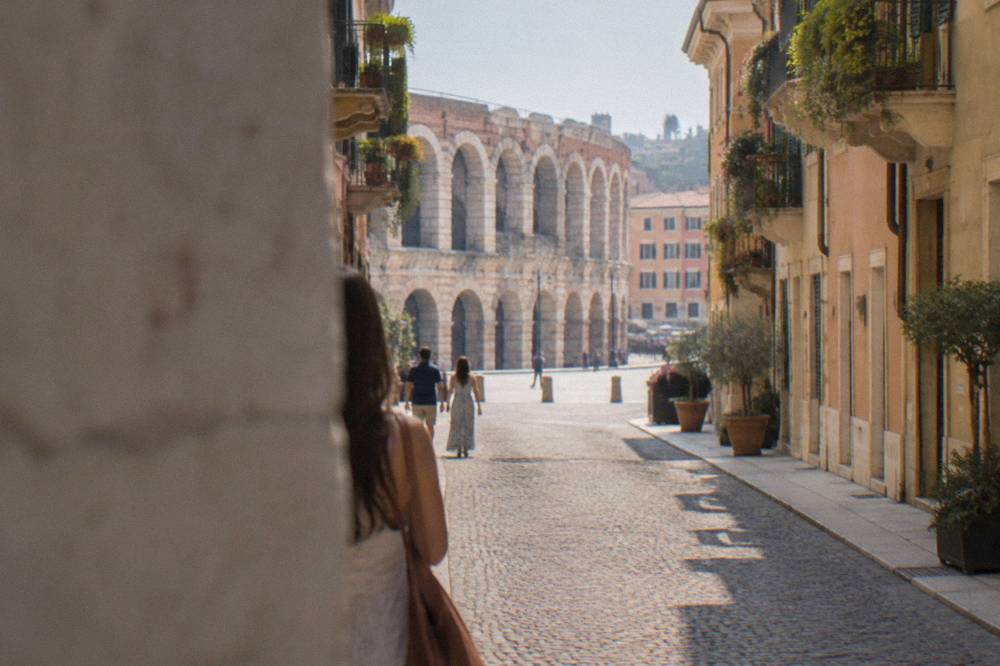 A narrow cobbled street in Verona's old town with pastel facades and balconies