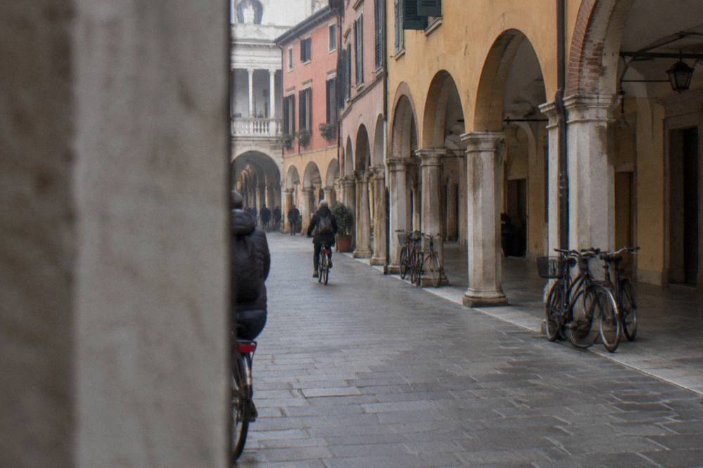 A Renaissance arcaded street in central Padua with cyclists and stone palazzi