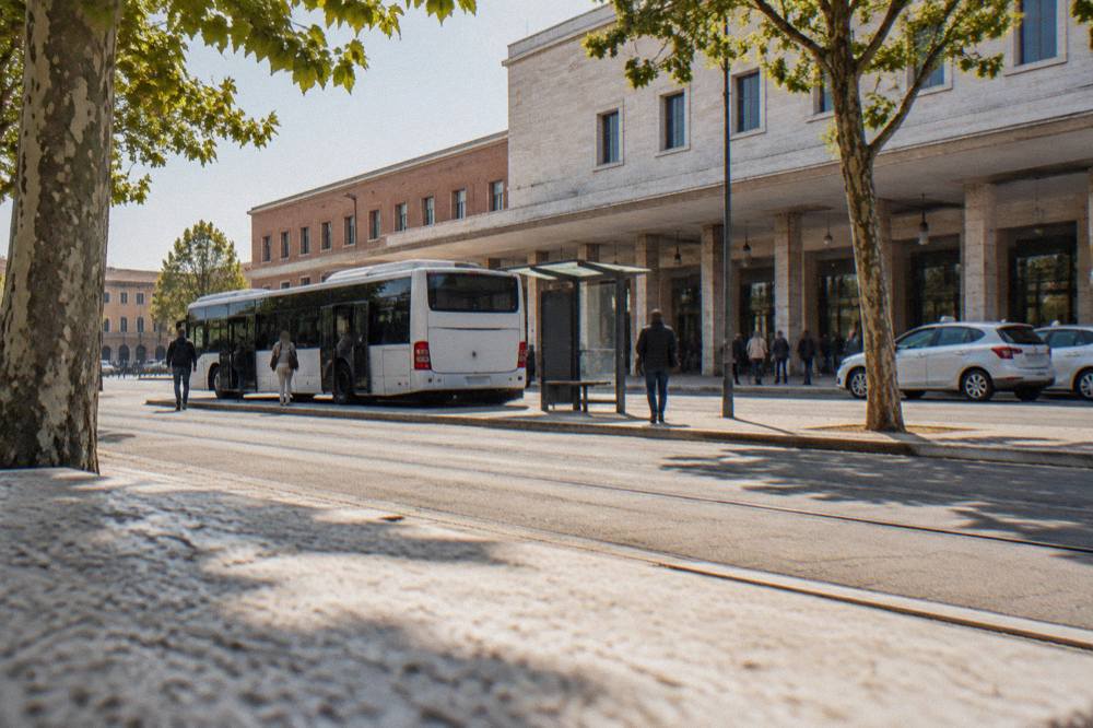 A regional airport bus waiting at a kerb outside an airport terminal building