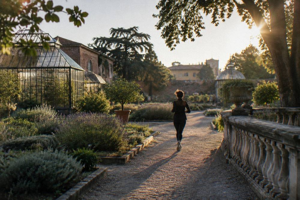 A renaissance botanical garden with historic brick walls, greenhouses and ordered plant beds
