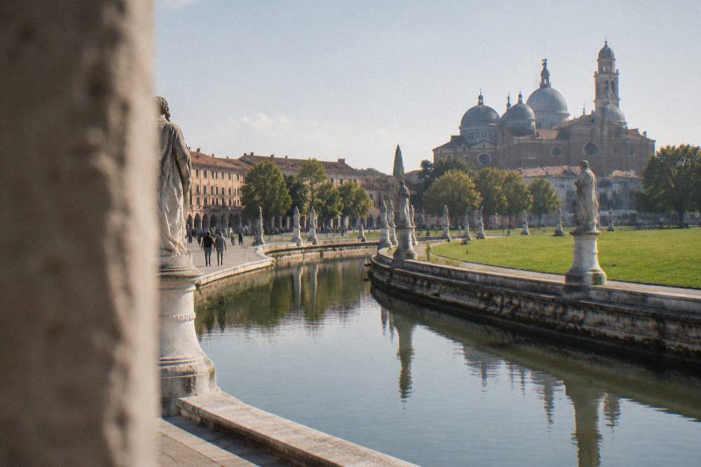 Wide open square of Prato della Valle in Padua with its canal ring and statues