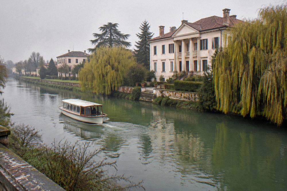 River boat cruising past a riverside villa on the Brenta Riviera