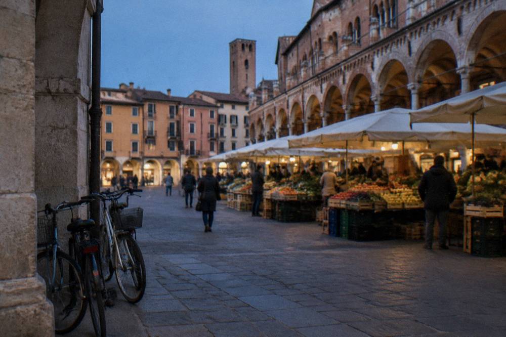 Bicycles leaning against a stone archway near a market square in Padua