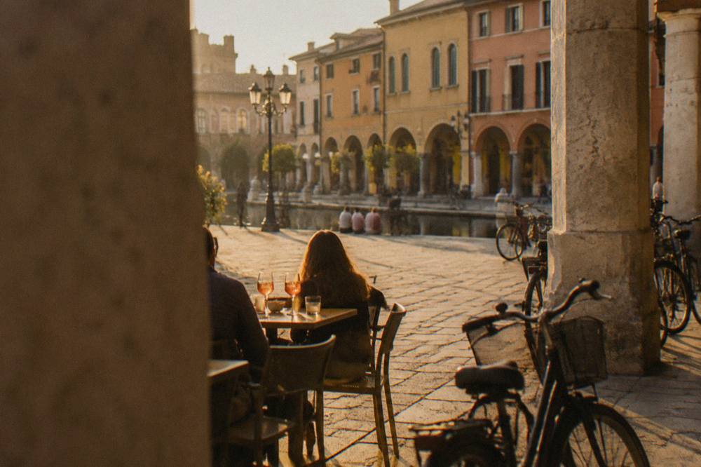 An evening table with drinks in a Padua square with bicycles nearby