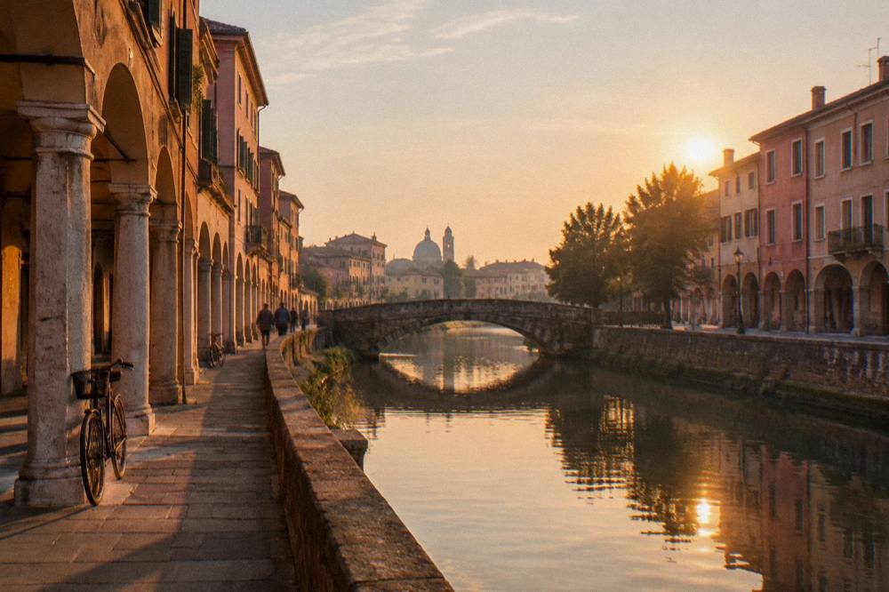 Evening light on a Padua canal with the silhouette of a bridge