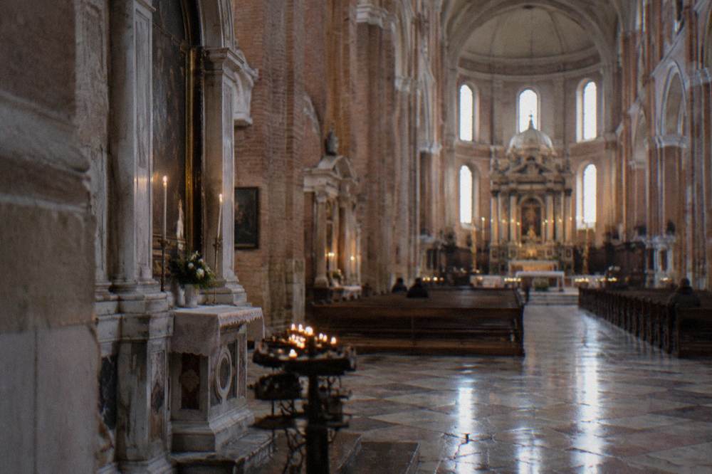 Nave of a large brick basilica with an ornate altar and side chapels
