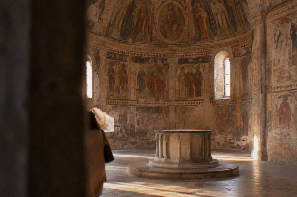 Ornate baptistery interior covered wall to wall in medieval frescoes