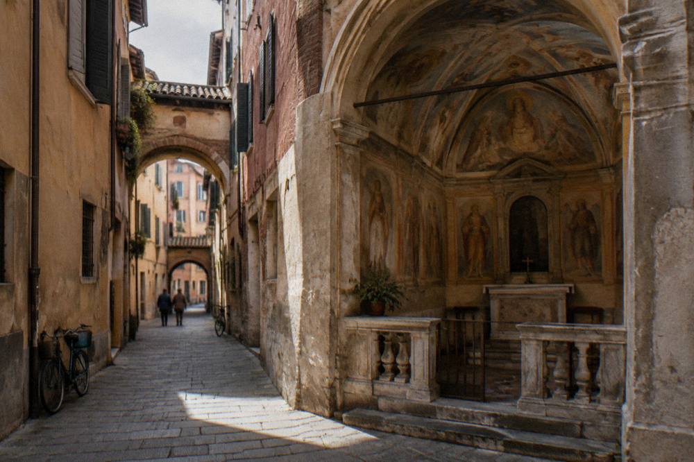 A small frescoed Italian oratory interior with vaulted ceiling and muted painted figures